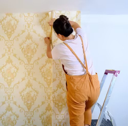 Technician expertly fixing wallpaper in a modern living room