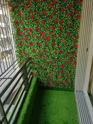 Vibrant red roses against a verdant green leafy wall